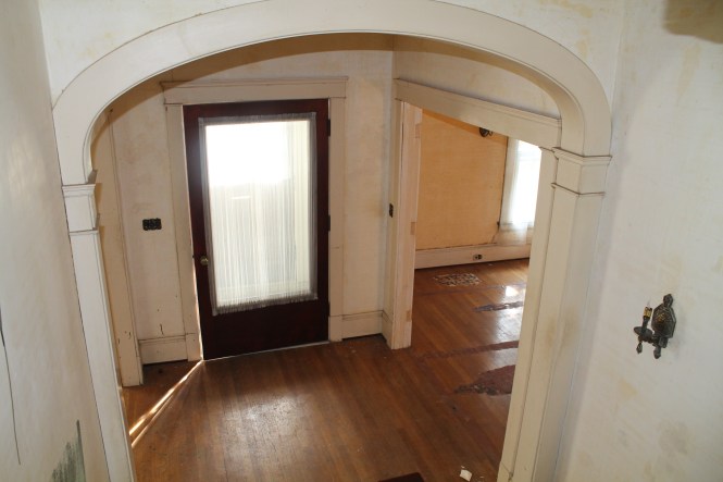 Looking down from the stairwell to the front entry.  To the left, the living room.  To the right, the dining room. 